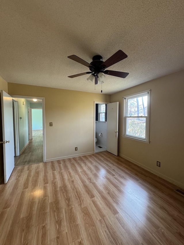 unfurnished room featuring a textured ceiling, light hardwood / wood-style flooring, and ceiling fan