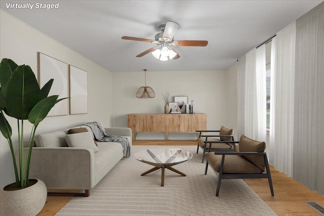 living room featuring light hardwood / wood-style flooring and ceiling fan