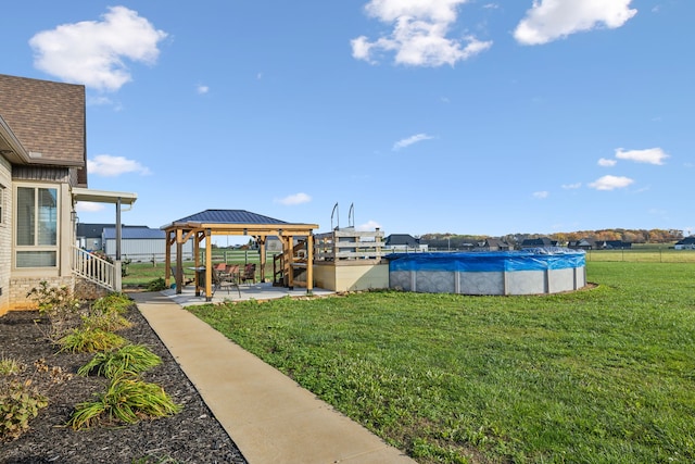 view of yard featuring a gazebo and a covered pool