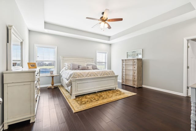 bedroom featuring multiple windows, ceiling fan, and dark hardwood / wood-style flooring