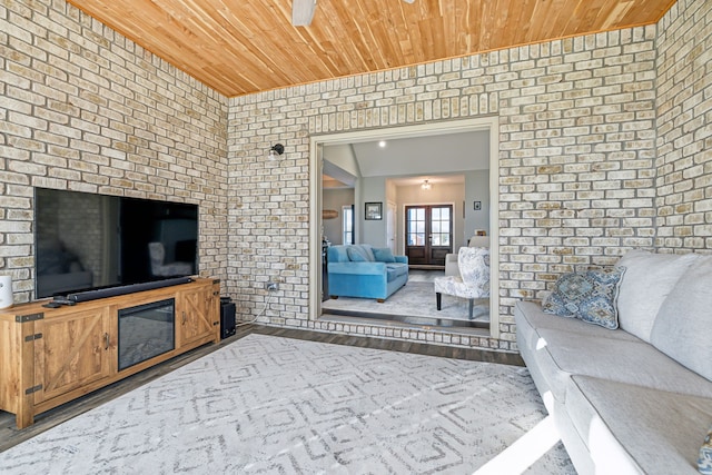 living room featuring wood ceiling, ceiling fan, brick wall, and hardwood / wood-style flooring