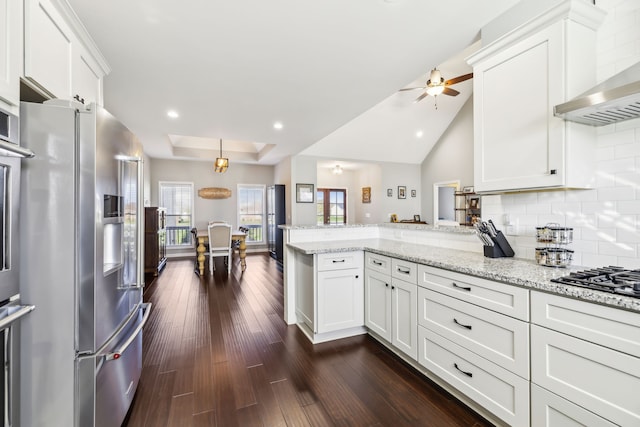 kitchen with kitchen peninsula, decorative backsplash, high quality fridge, dark hardwood / wood-style flooring, and white cabinetry