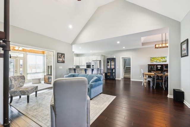 living room featuring dark hardwood / wood-style flooring and high vaulted ceiling