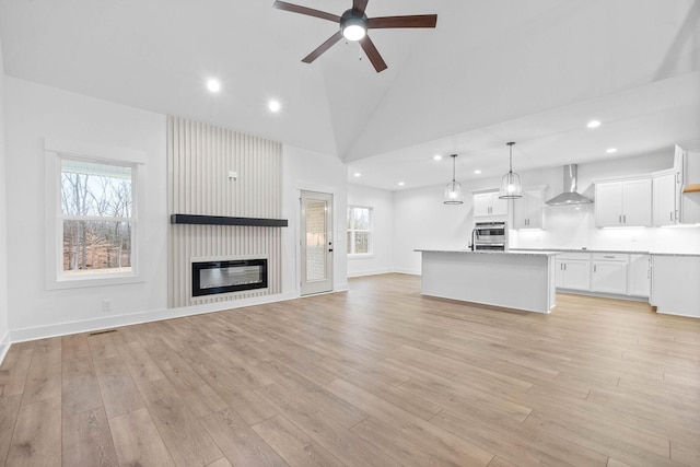 unfurnished living room with plenty of natural light, a fireplace, and light hardwood / wood-style flooring