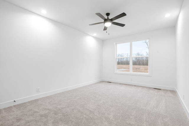 carpeted spare room featuring ceiling fan