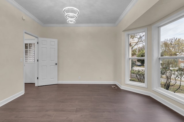 empty room with a wealth of natural light, ornamental molding, dark wood-type flooring, and a notable chandelier