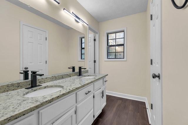 bathroom featuring wood-type flooring, vanity, and a textured ceiling