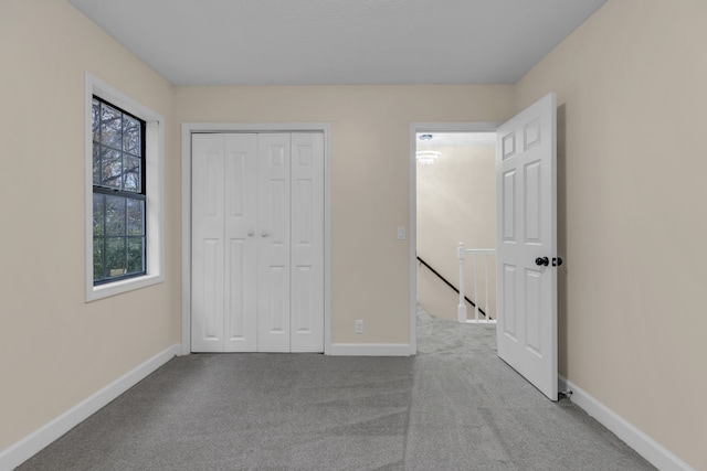 unfurnished bedroom with light carpet and a closet