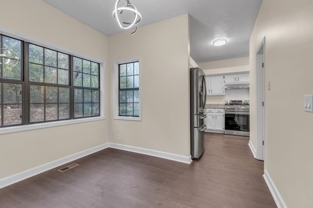 interior space with a notable chandelier and dark hardwood / wood-style flooring