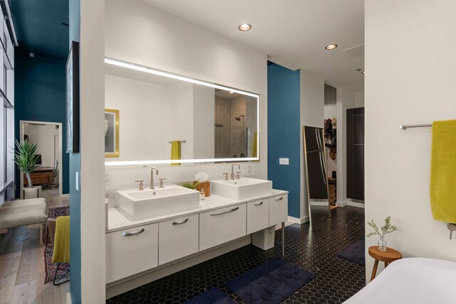 bathroom with hardwood / wood-style flooring, vanity, and walk in shower