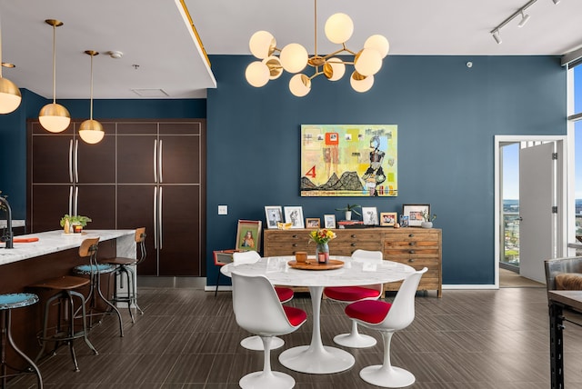 dining room featuring rail lighting, an inviting chandelier, and a wealth of natural light