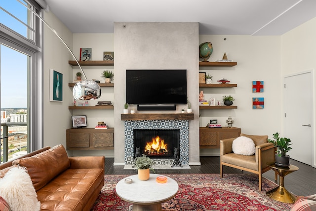 living room with a fireplace, plenty of natural light, and dark wood-type flooring