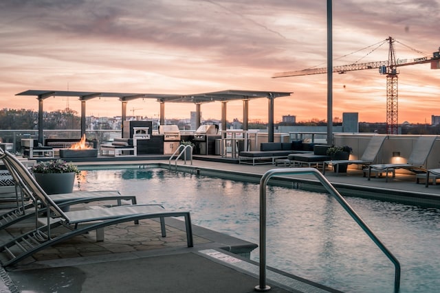 pool at dusk featuring a fire pit and a grill