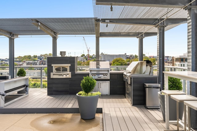 deck with a pergola, area for grilling, and exterior kitchen