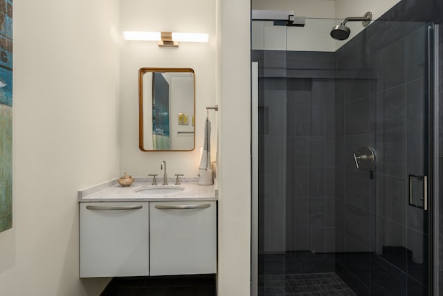 bathroom featuring tile patterned flooring, vanity, and a shower with shower door