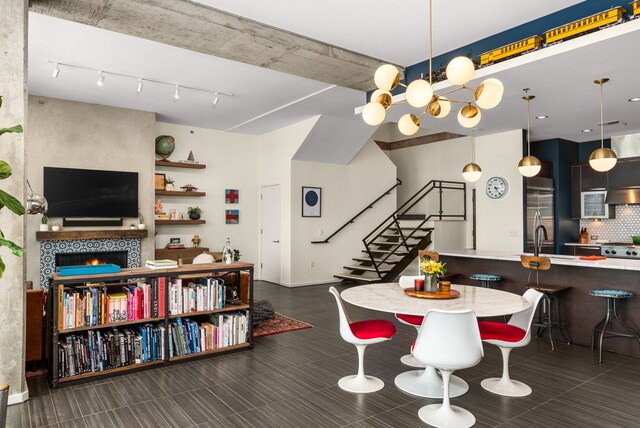 dining space with a fireplace, a notable chandelier, and sink