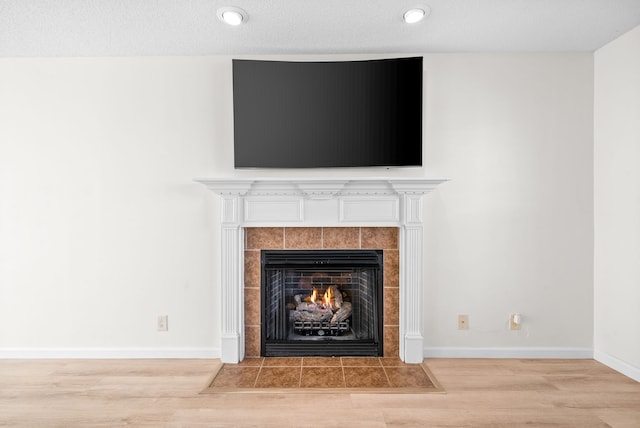 details featuring a textured ceiling, wood-type flooring, and a fireplace