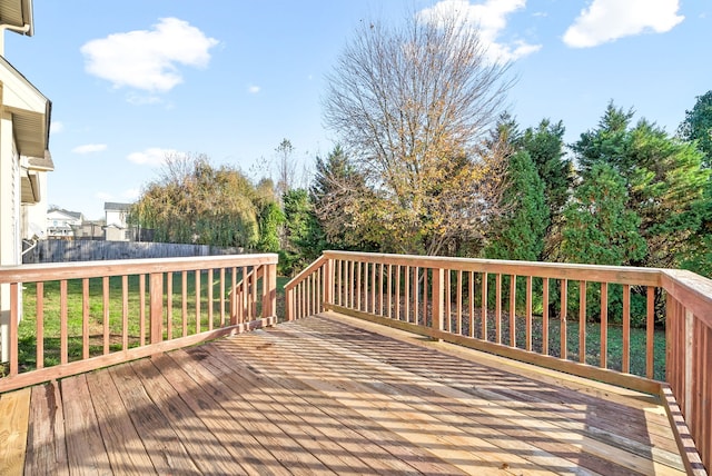 wooden terrace featuring a lawn