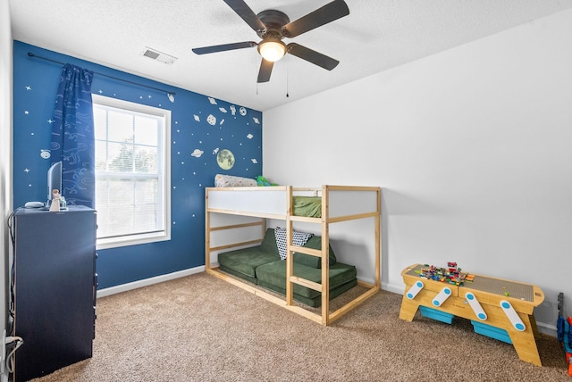 bedroom featuring carpet flooring, ceiling fan, and a textured ceiling