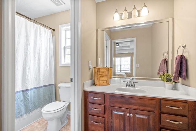 bathroom featuring tile patterned flooring, vanity, toilet, and a wealth of natural light