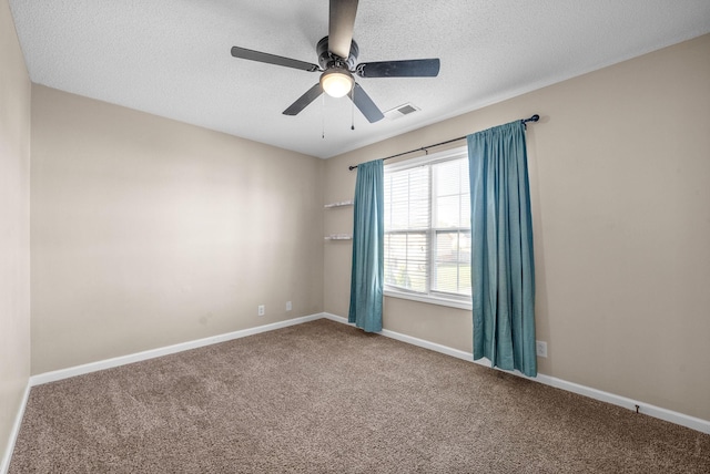 carpeted empty room with ceiling fan and a textured ceiling