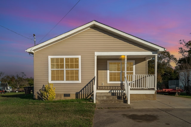 bungalow-style home with a porch and a yard