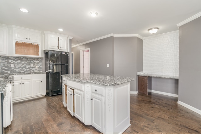 kitchen featuring dark hardwood / wood-style floors, a kitchen island, black fridge, and white cabinetry