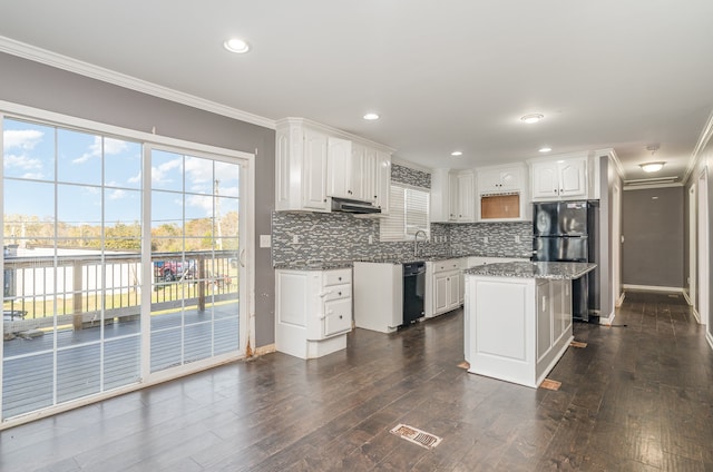 kitchen with decorative backsplash, dark hardwood / wood-style flooring, a kitchen island, crown molding, and white cabinetry