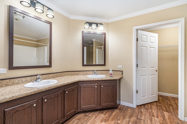 bathroom featuring hardwood / wood-style floors, vanity, a shower, and ornamental molding