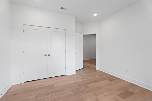 unfurnished bedroom with a closet and light hardwood / wood-style flooring