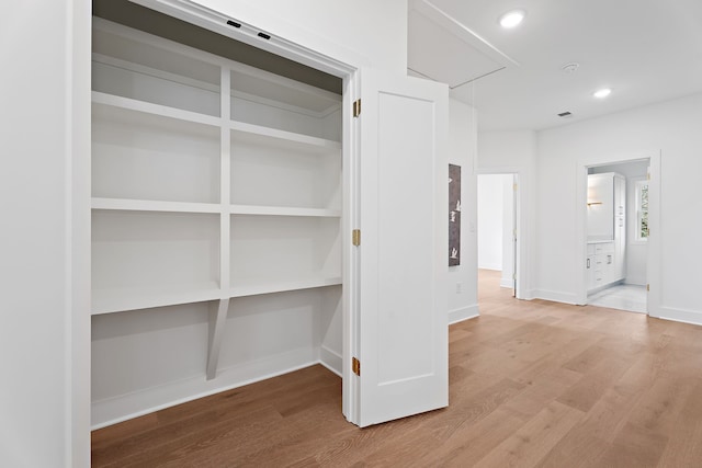 hallway with hardwood / wood-style flooring