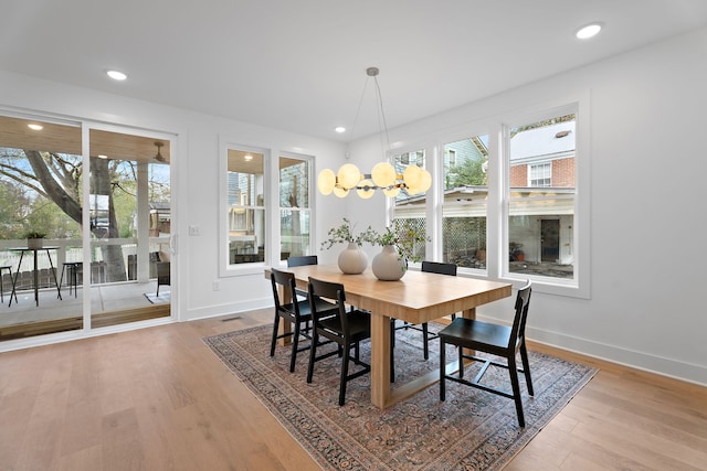 dining room with wood-type flooring and a chandelier