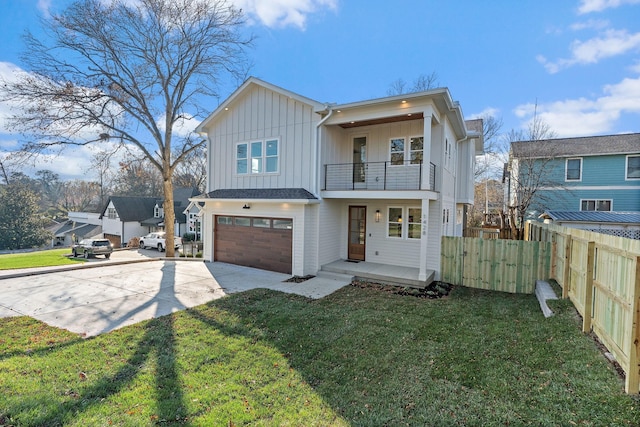 view of front of home featuring a garage, a balcony, and a front yard