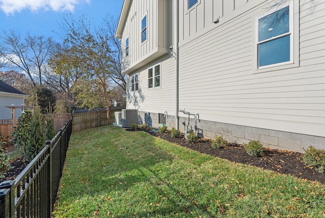 view of side of property featuring a lawn and central air condition unit