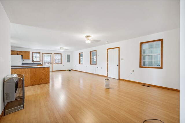 unfurnished living room featuring ceiling fan and light wood-type flooring