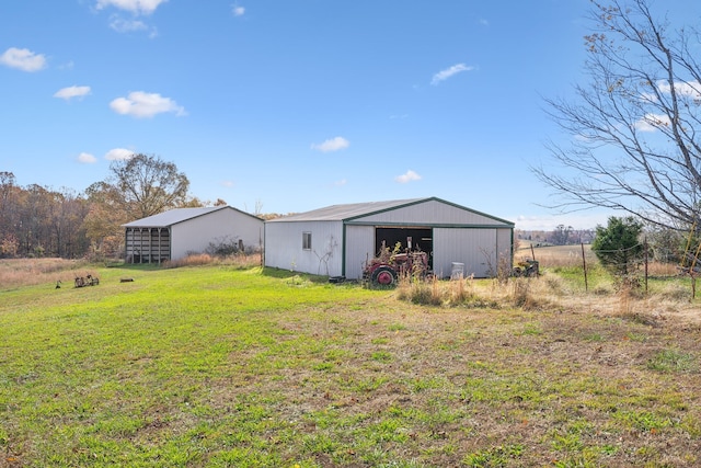 rear view of property with a lawn and an outbuilding