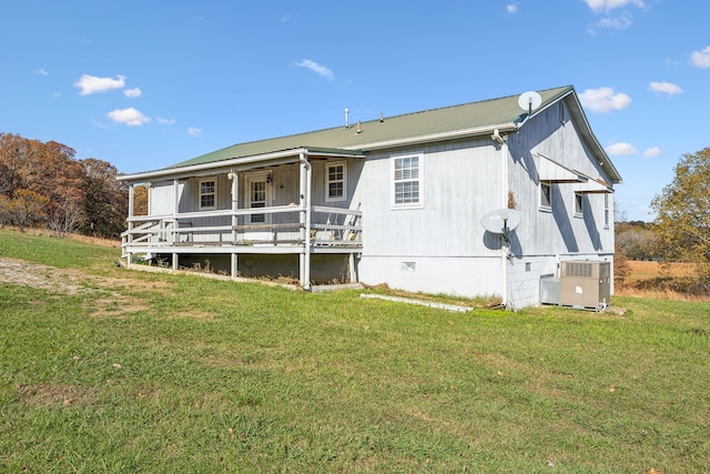 rear view of house featuring covered porch, a yard, and central air condition unit