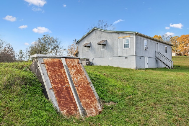 view of outbuilding with a lawn and cooling unit