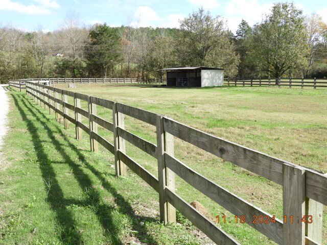 view of yard with a rural view and an outdoor structure