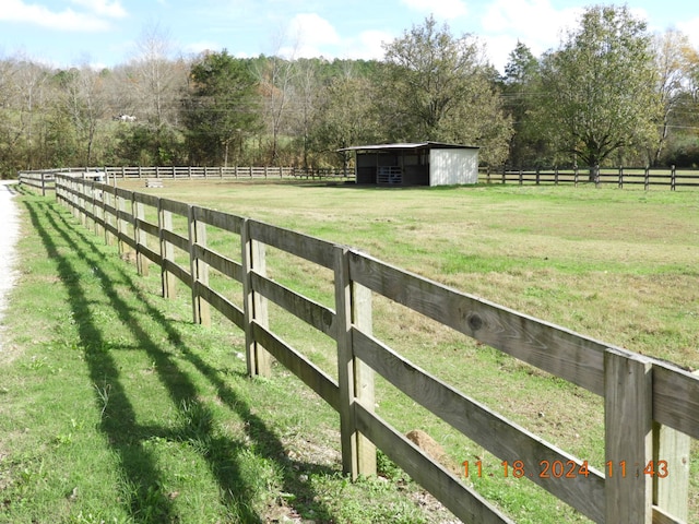 view of yard with an outbuilding and a rural view