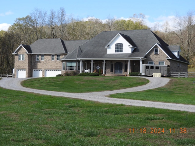 view of front of home with a porch, a garage, and a front yard