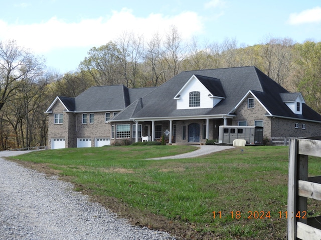 view of front of home with a garage, covered porch, and a front lawn