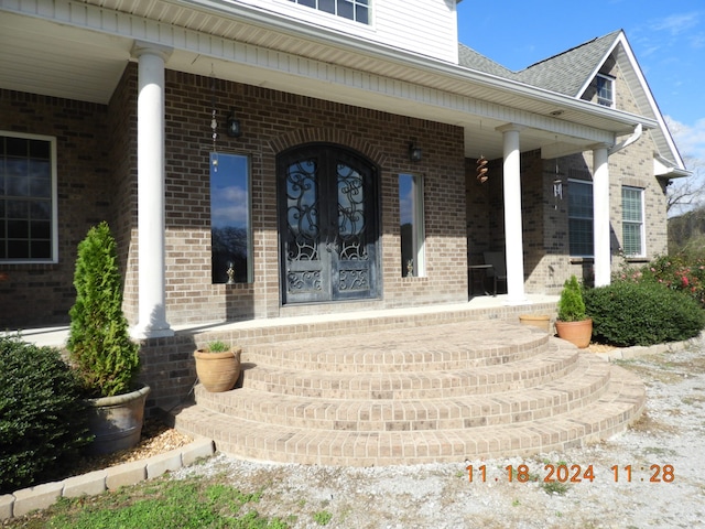 entrance to property with covered porch and french doors