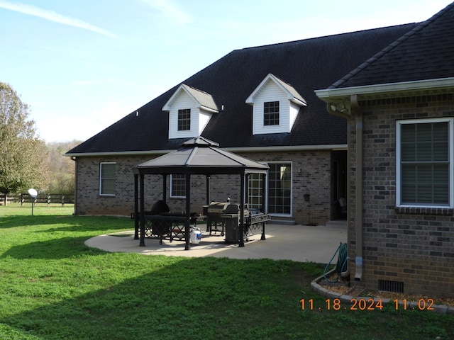 back of property with a gazebo, a yard, and a patio