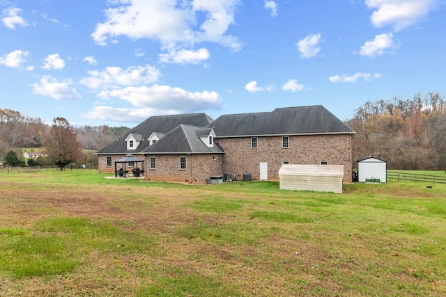 back of property featuring a gazebo, a storage shed, and a lawn