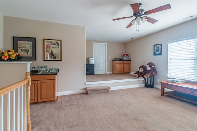 interior space with ceiling fan and light carpet