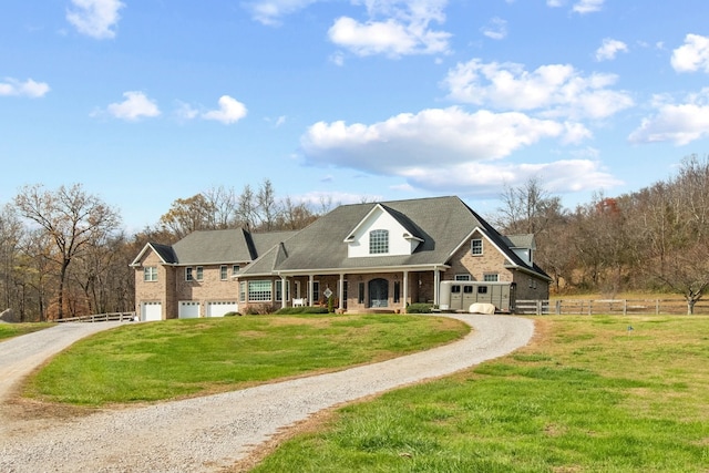 view of front facade with a front yard, a porch, and a garage