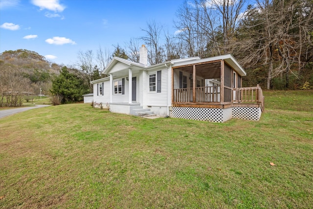 view of front facade featuring a front lawn and a sunroom