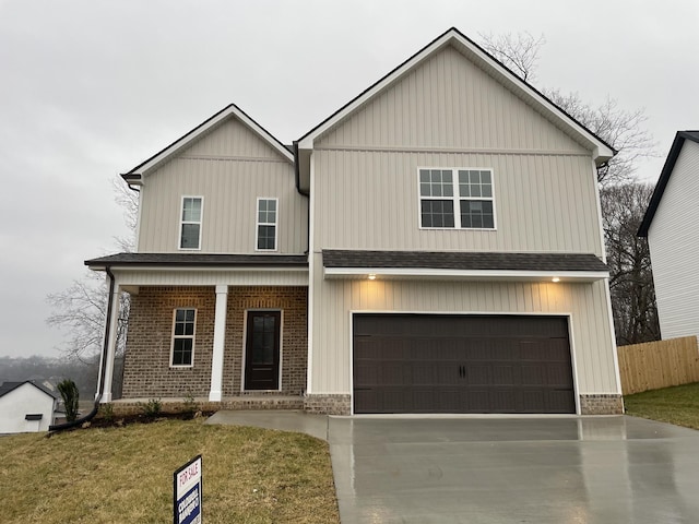 view of front of property featuring a porch, a garage, and a front lawn