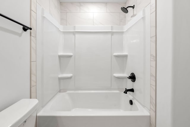 bathroom with toilet and tiled shower / bath